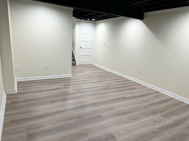 finished basement with stairs, baseboards, and wood finished floors