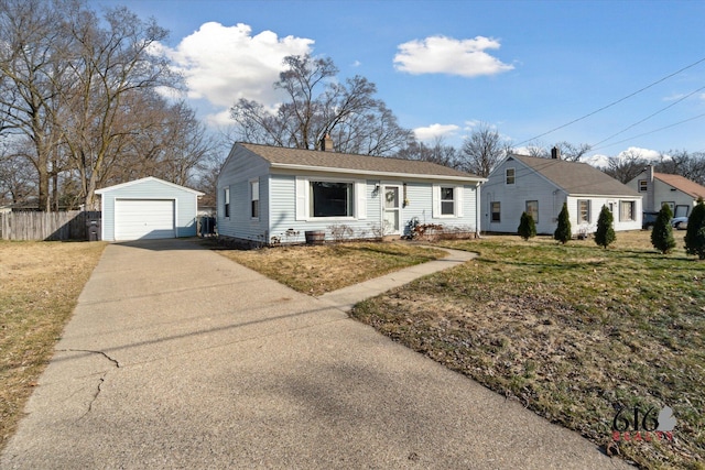 view of front facade with an outbuilding, fence, concrete driveway, a garage, and a chimney