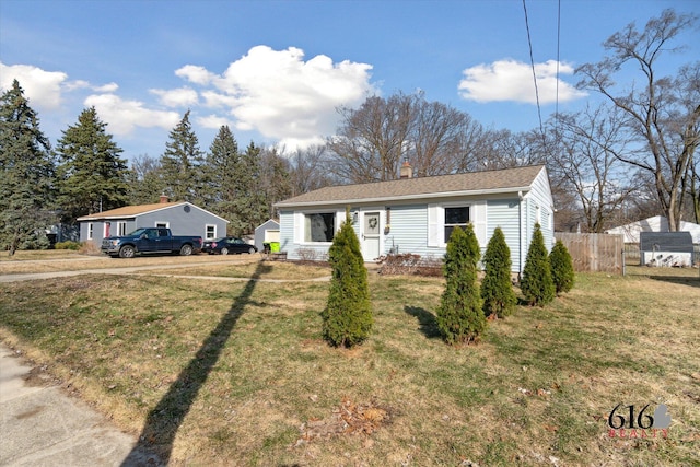 single story home featuring a chimney, a front yard, and fence