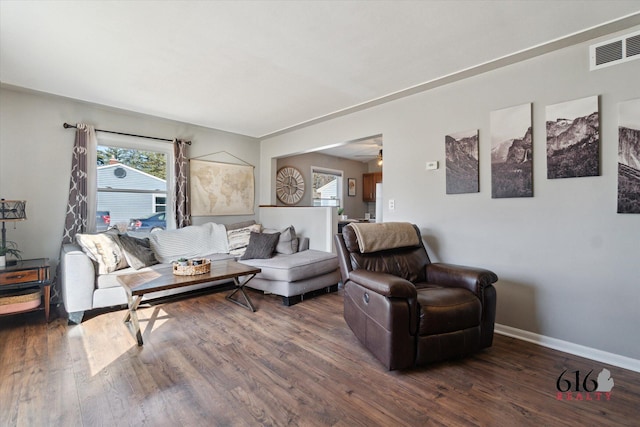 living room with wood finished floors, visible vents, a wealth of natural light, and baseboards