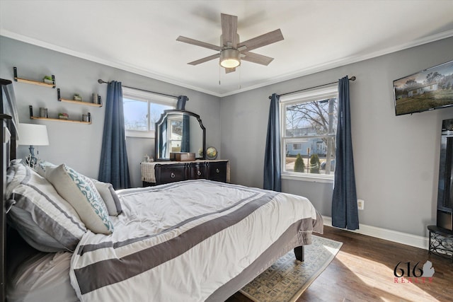 bedroom with baseboards, a ceiling fan, wood finished floors, and crown molding