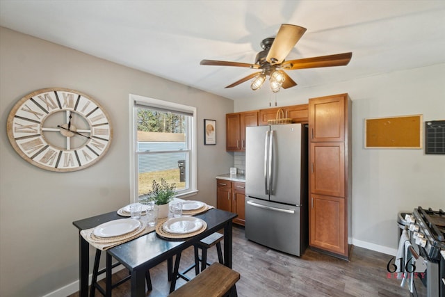 dining room with dark wood finished floors, a ceiling fan, and baseboards