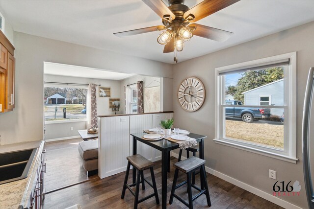 dining area featuring baseboards, dark wood-style floors, and a ceiling fan