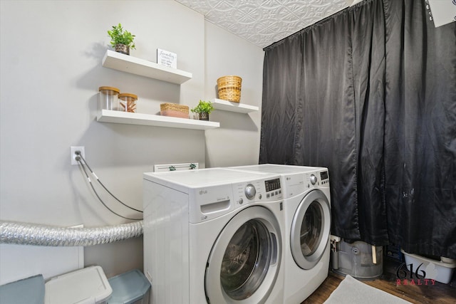 clothes washing area featuring washing machine and clothes dryer, laundry area, and dark wood-type flooring