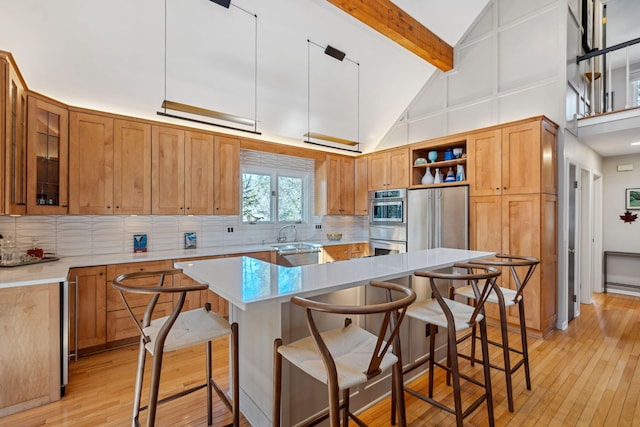 kitchen with tasteful backsplash, a sink, a center island, beam ceiling, and open shelves