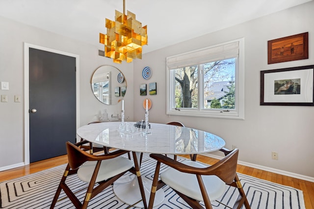 dining space featuring baseboards and light wood finished floors