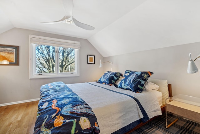 bedroom with baseboards, lofted ceiling, wood finished floors, and a ceiling fan