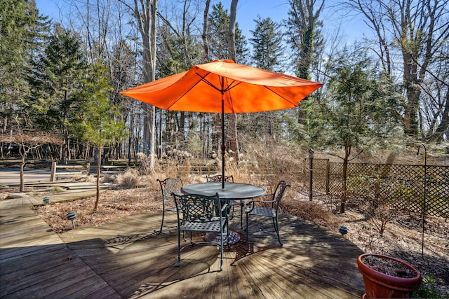 deck with outdoor dining area and fence