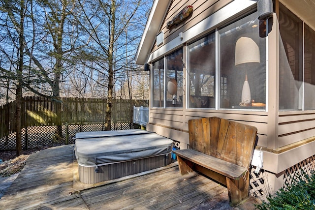 wooden deck with a sunroom, a covered hot tub, and fence