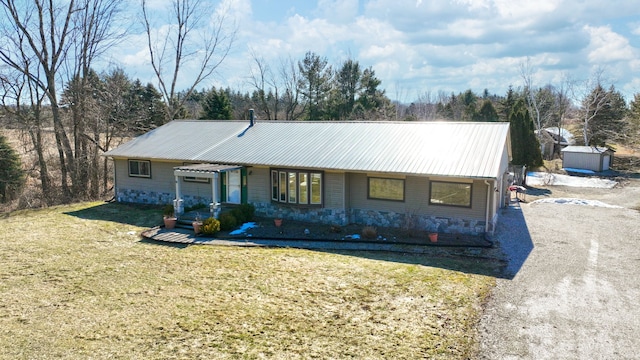 view of front of property with metal roof and a front yard