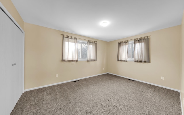 unfurnished bedroom featuring a closet, visible vents, carpet flooring, and baseboards