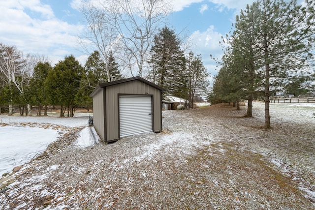 snow covered garage with a detached garage