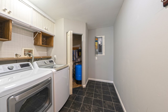 washroom with baseboards, electric panel, cabinet space, separate washer and dryer, and dark tile patterned floors