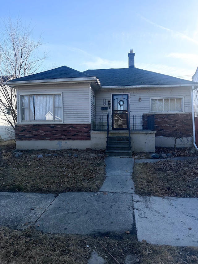 view of front of home featuring roof with shingles and a chimney