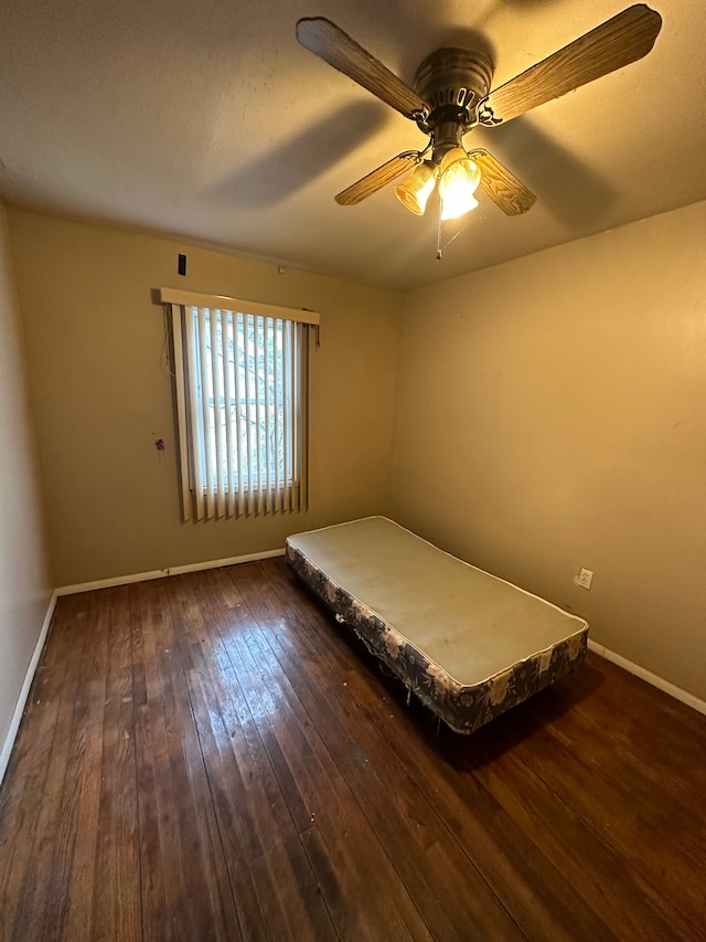 unfurnished bedroom with a ceiling fan, baseboards, and hardwood / wood-style floors