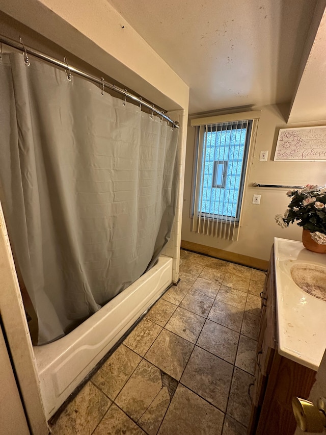 bathroom featuring shower / bath combination with curtain, vanity, and baseboards