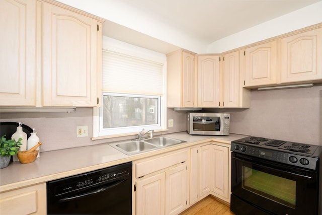 kitchen with black appliances, light countertops, and a sink