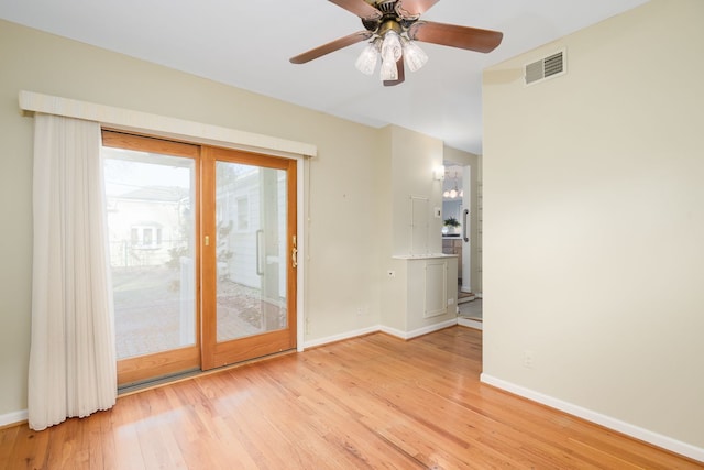 empty room featuring visible vents, light wood-style flooring, a ceiling fan, and baseboards