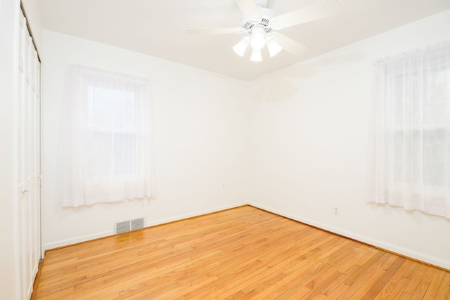 unfurnished room featuring visible vents, ceiling fan, baseboards, and wood-type flooring