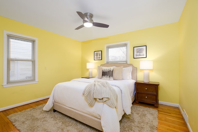 bedroom featuring visible vents, wood finished floors, baseboards, and ceiling fan