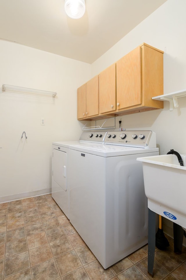 laundry area featuring light tile patterned floors, baseboards, cabinet space, and washing machine and clothes dryer