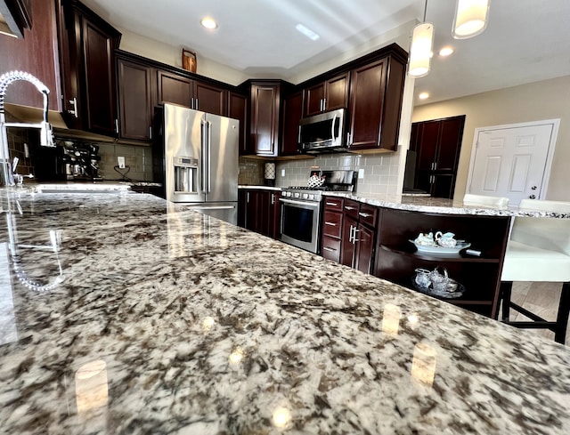 kitchen featuring pendant lighting, open shelves, light stone counters, tasteful backsplash, and stainless steel appliances