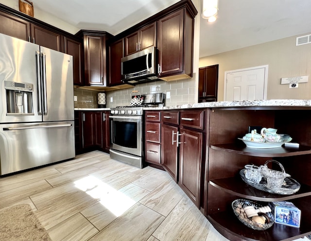 kitchen with tasteful backsplash, visible vents, light stone counters, appliances with stainless steel finishes, and open shelves