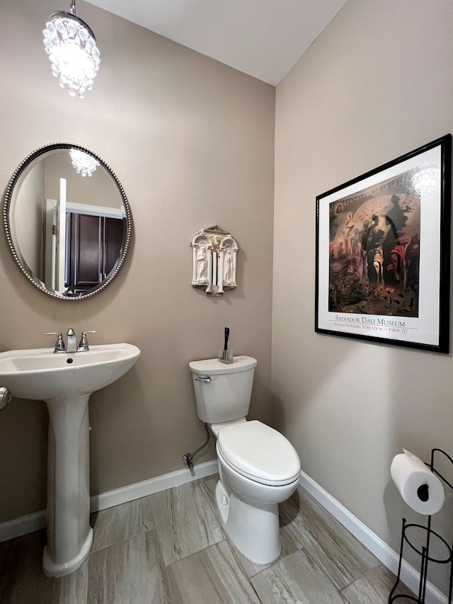 half bathroom with toilet and baseboards