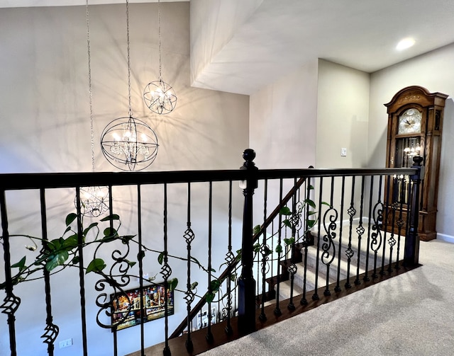 hallway with an inviting chandelier, carpet flooring, and an upstairs landing