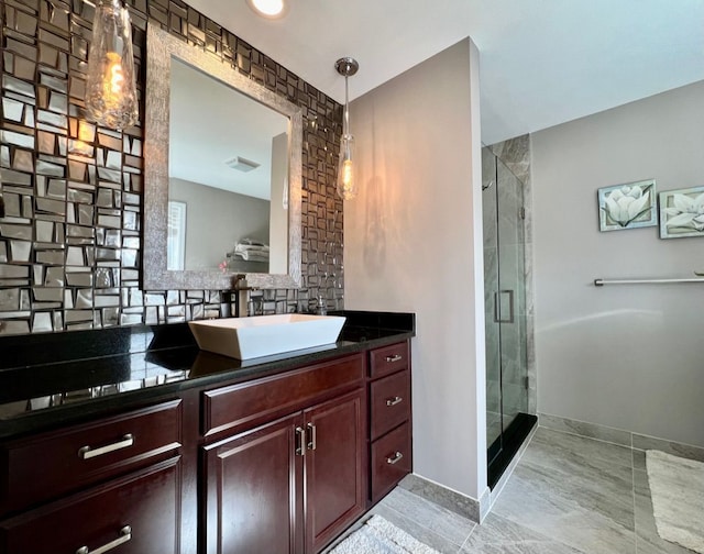 full bath featuring vanity, visible vents, baseboards, a stall shower, and backsplash