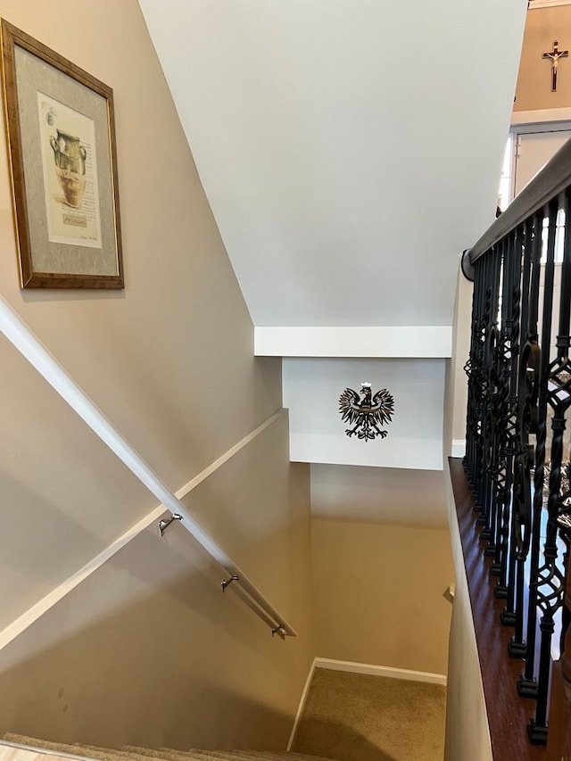 stairway featuring baseboards and carpet floors