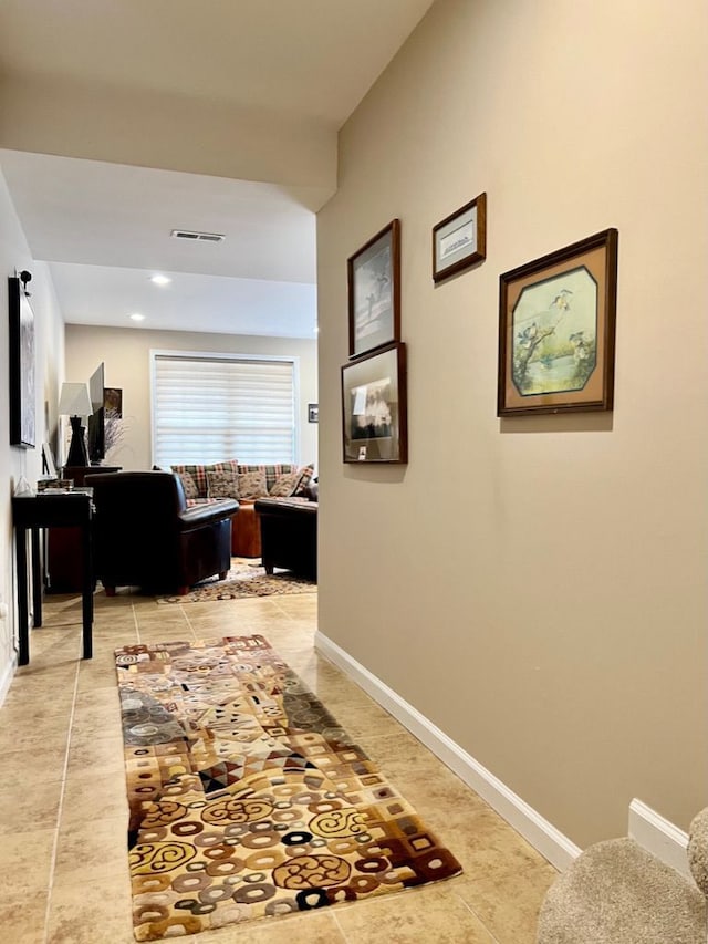 hallway featuring light tile patterned floors, visible vents, baseboards, and recessed lighting