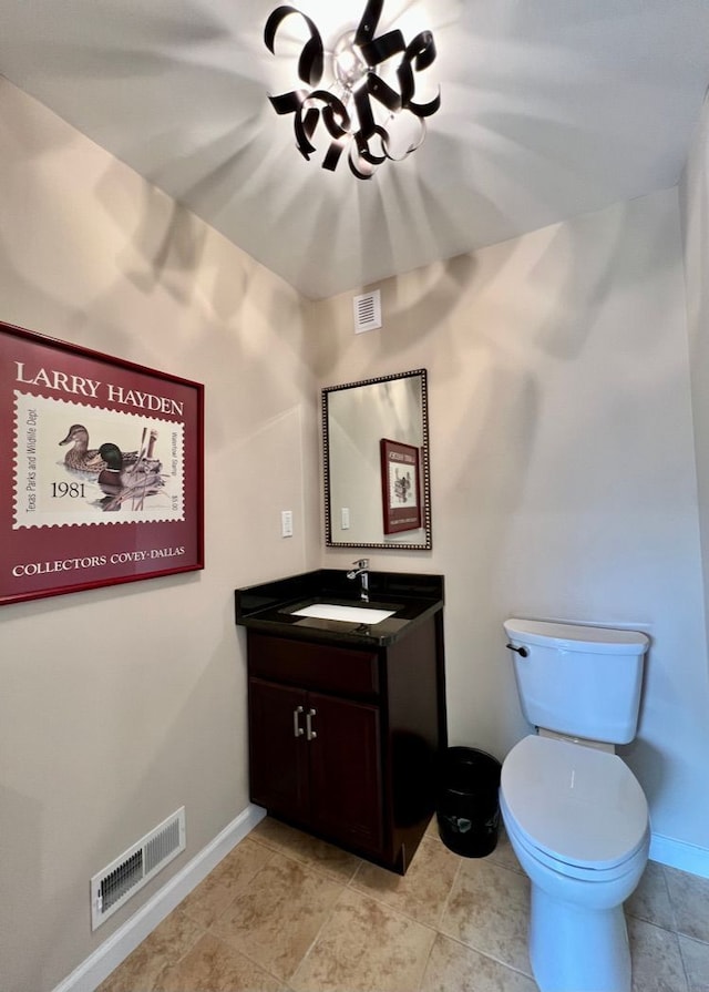 bathroom featuring visible vents, baseboards, toilet, and vanity