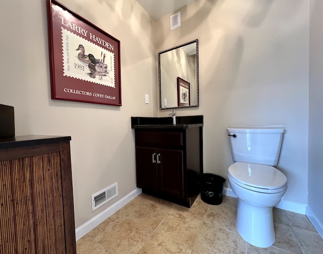 half bathroom with visible vents, toilet, vanity, and baseboards