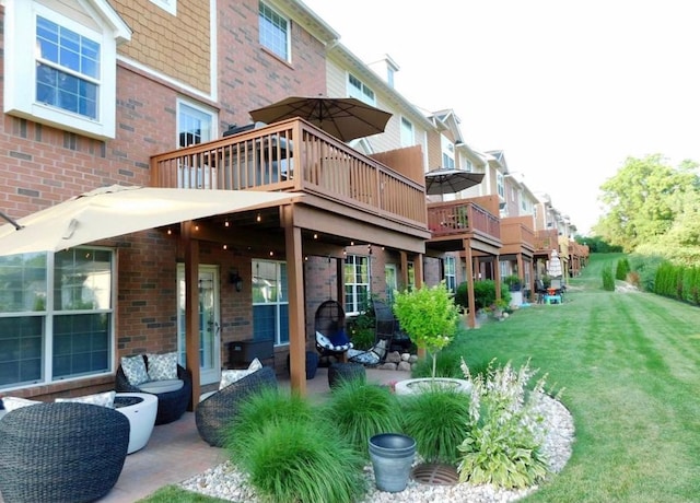 rear view of property with a lawn, a deck, a patio, a residential view, and brick siding