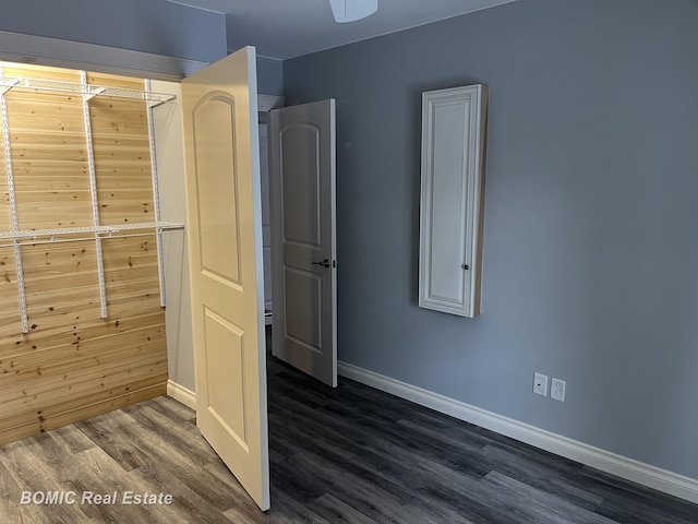 interior space with baseboards and dark wood-type flooring