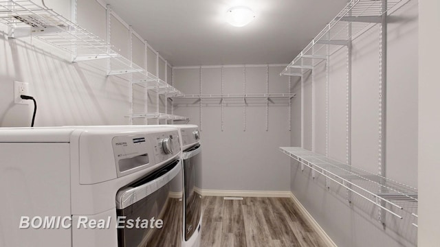 walk in closet with wood finished floors and washer and clothes dryer
