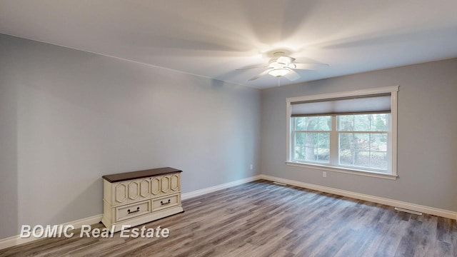 empty room with wood finished floors, baseboards, and ceiling fan