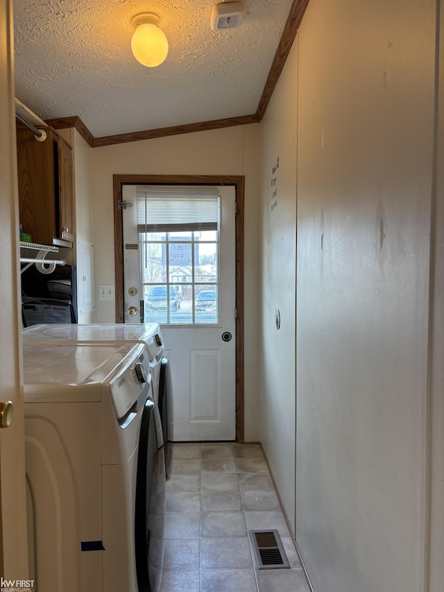 laundry room with independent washer and dryer, a textured ceiling, and crown molding