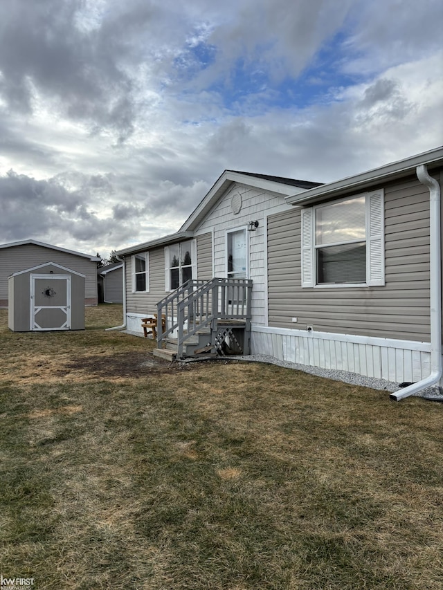 view of front of home with a front lawn, a storage unit, and an outdoor structure