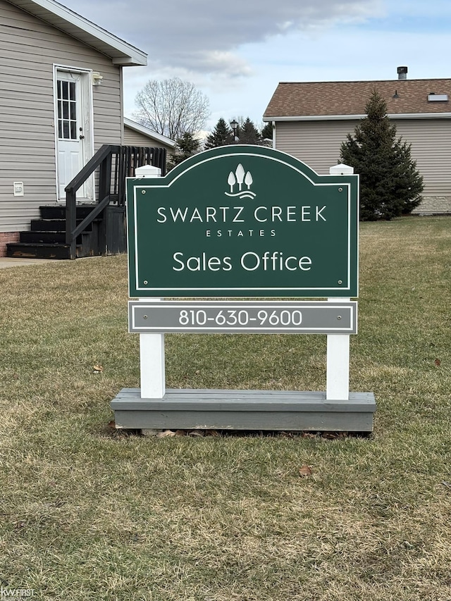 community / neighborhood sign featuring a yard