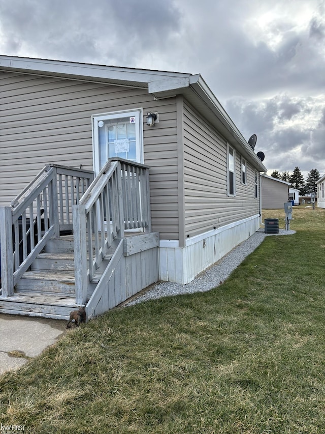 exterior space featuring central AC unit and a lawn