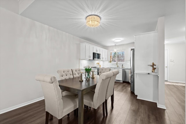 dining room featuring dark wood finished floors and baseboards