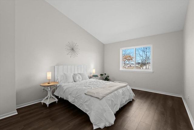 bedroom featuring dark wood finished floors, lofted ceiling, and baseboards