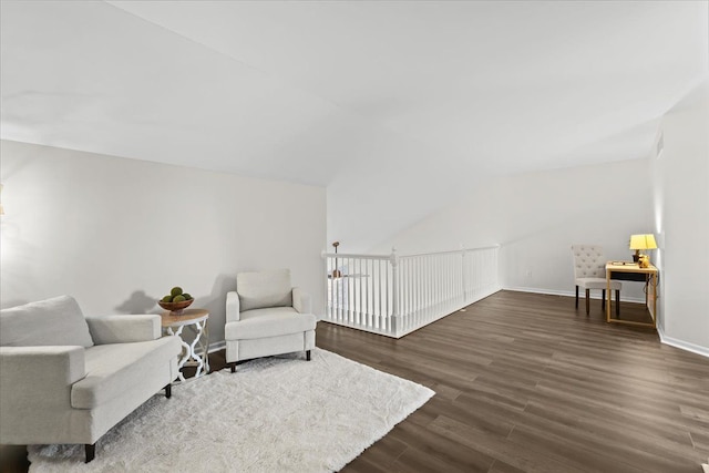 living area with vaulted ceiling, dark wood-style floors, baseboards, and visible vents