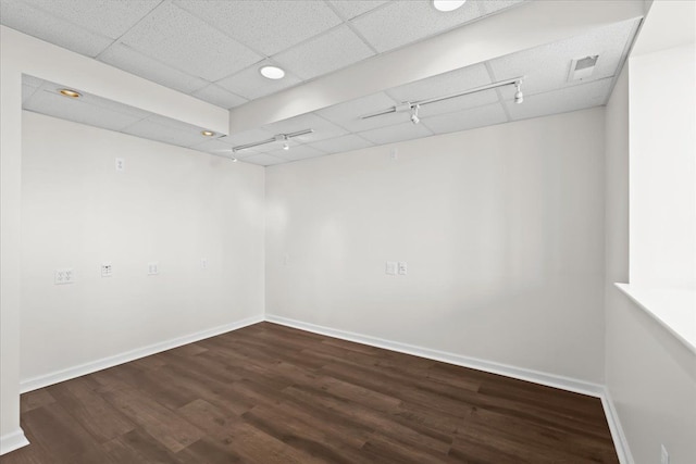 unfurnished room featuring visible vents, a paneled ceiling, baseboards, and wood finished floors