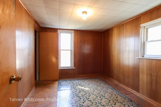 empty room with wood walls and wood finished floors