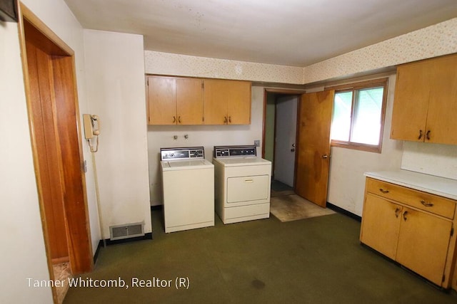 clothes washing area with visible vents, cabinet space, washer and dryer, and wallpapered walls