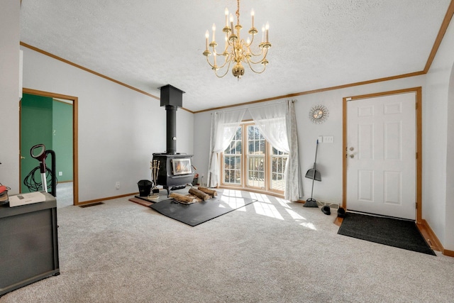 carpeted living area with a textured ceiling, ornamental molding, and a wood stove