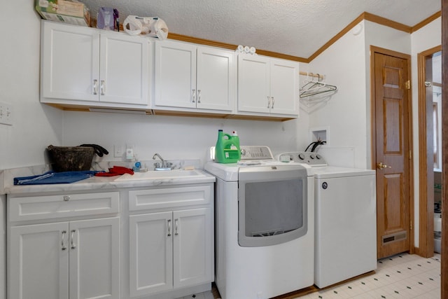 laundry room featuring ornamental molding, cabinet space, a textured ceiling, independent washer and dryer, and a sink